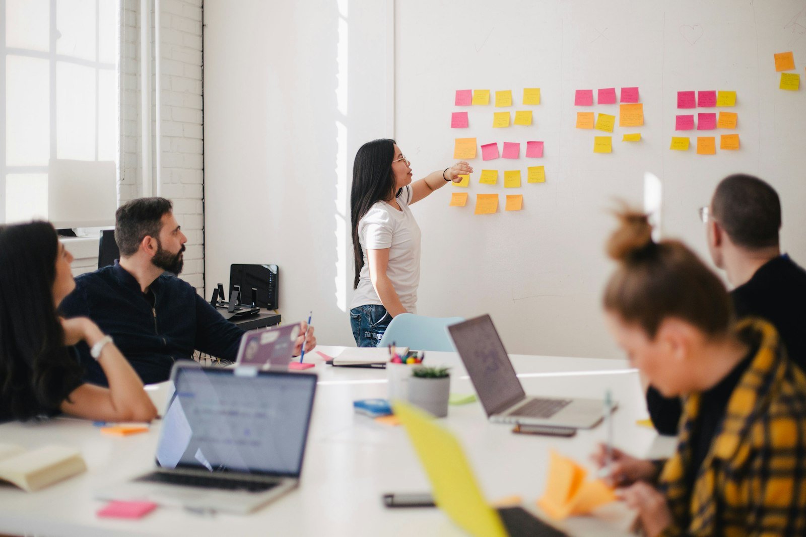 Team collaborating around a wall of sticky notes in a workshop